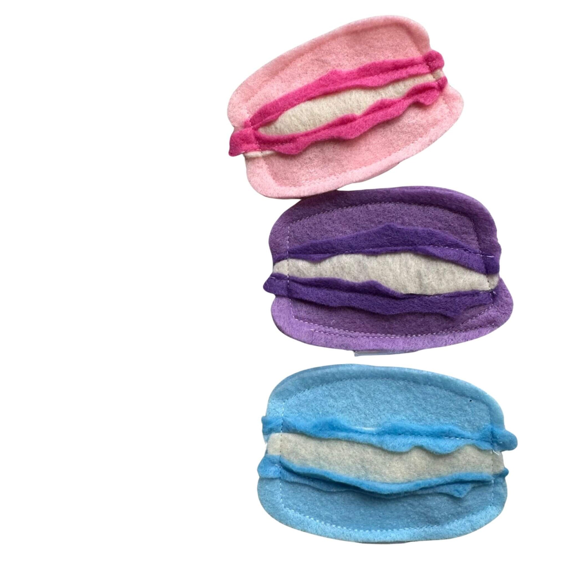 Close-up of pink, blue, and lavender macaron catnip cat toys made by CatnipTakeout.